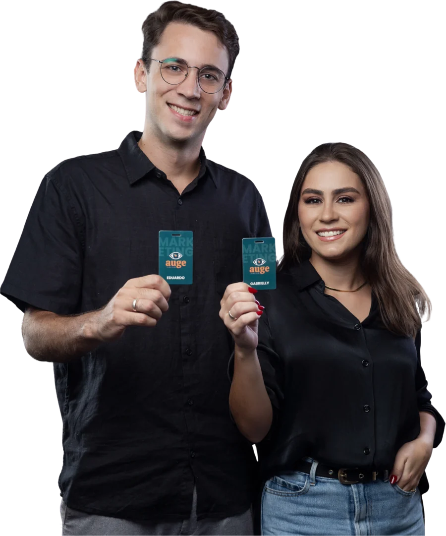 Eduardo e Gabrielly, sócios da Auge, segurando os crachás da agência